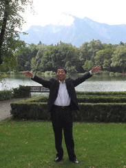 Sam in Austria with arms raised in praise